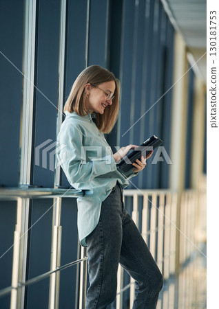 Digital tablet in hands. Young woman in airport hall 130181753