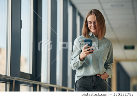 Smartphone in hands. Young woman in airport hall 130181792