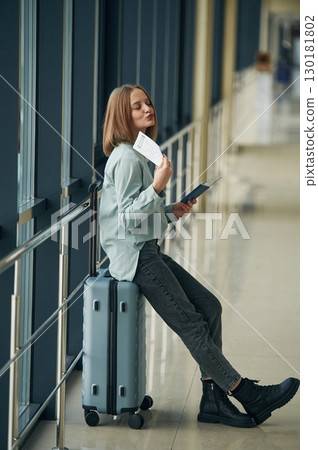 Waiting in the airport hall. Young woman with luggage 130181802