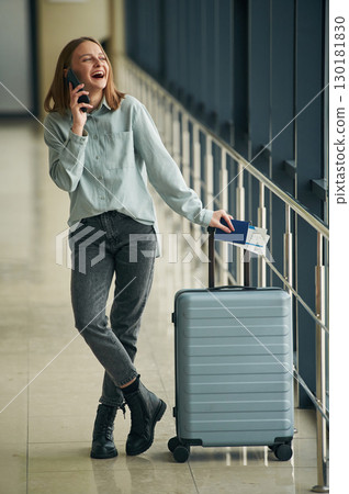 Luggage bag and smartphone. Young woman in airport hall 130181830