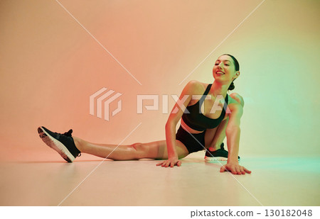 Young fitness woman in sportive clothes against background in studio Young fitness woman in sportive clothes against background in studio 130182048