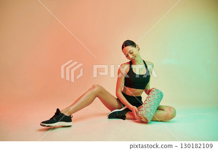 Young fitness woman in sportive clothes against background in studio 130182109