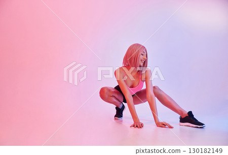 Soft pink lighting. Sportive woman with wig is against background Soft pink lighting. Sportive woman with wig is against background 130182149