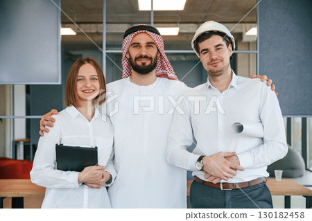 Standing together. Muslim businessman in traditional outfit with colleagues in office 130182458