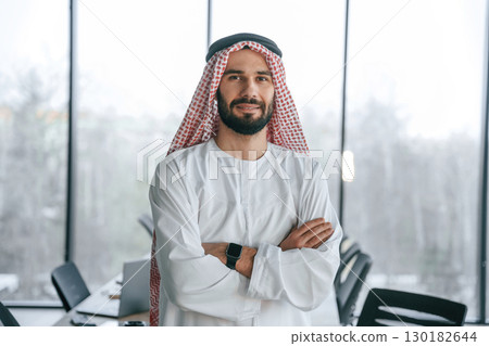 In traditional outfit. Successful Muslim businessman is in his office 130182644