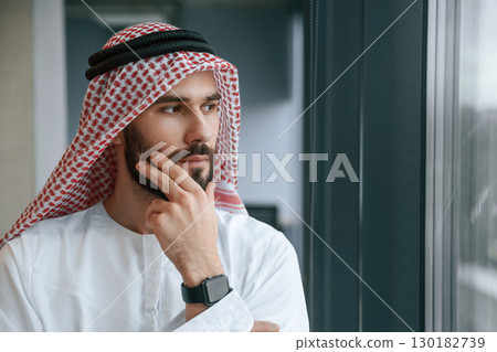 Close up portrait. Successful Muslim businessman in traditional outfit in his office Close up portrait. Successful Muslim businessman in traditional outfit in his office 130182739