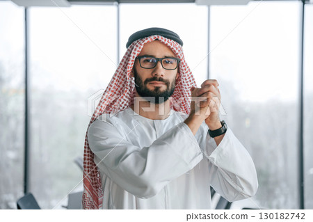 Young investor is standing. Successful Muslim businessman in traditional outfit in his office 130182742