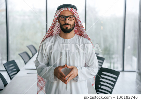 In glasses. Successful Muslim businessman in traditional outfit in his office In glasses. Successful Muslim businessman in traditional outfit in his office 130182746