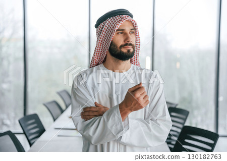 Conception of rich person. Successful Muslim businessman in traditional outfit in his office 130182763