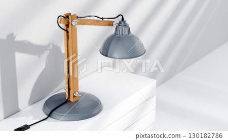 Retro or vintage style desk lamp, classic wooden arm with metal base and grey colored canopy, against white background, isolated. Retro or vintage style desk lamp, classic wooden arm with metal base and grey colored canopy, against white background, isolated. 130182786