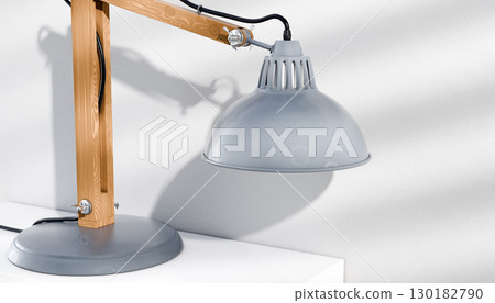 Retro or vintage style desk lamp, classic wooden arm with metal base and grey colored canopy, against white background, isolated. Retro or vintage style desk lamp, classic wooden arm with metal base and grey colored canopy, against white background, isolated. 130182790