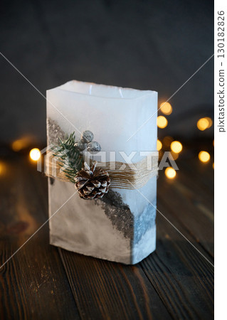 Wooden surface. Handmade beautiful decorative candle on the background 130182826