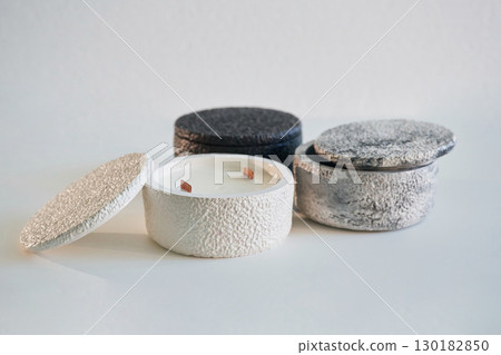 In capacities. Handmade beautiful decorative candles on the background In capacities. Handmade beautiful decorative candles on the background 130182850