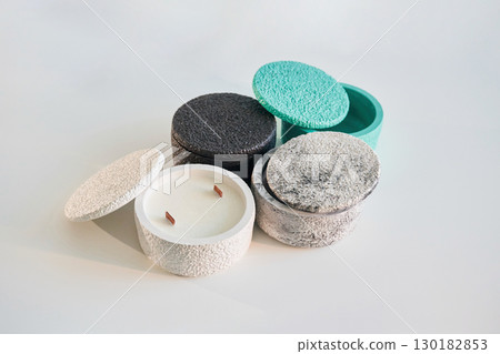 In capacities. Handmade beautiful decorative candles on the background In capacities. Handmade beautiful decorative candles on the background 130182853