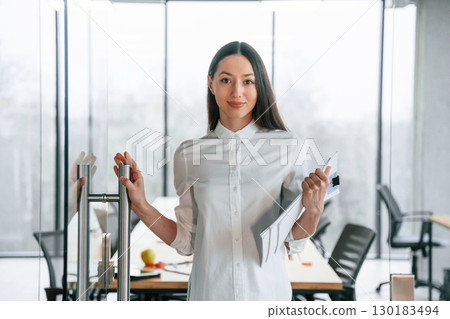 Against big panoramic windows. Businesswoman is indoors in the office 130183494