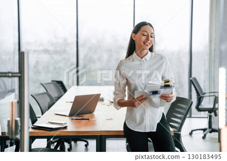In the meeting room. Businesswoman is indoors in the office In the meeting room. Businesswoman is indoors in the office 130183495