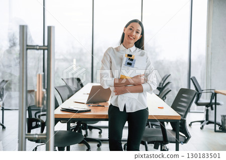 Against big panoramic windows. Businesswoman is indoors in the office 130183501