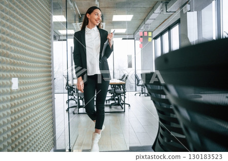 Walking in the office. Businesswoman is indoors Walking in the office. Businesswoman is indoors 130183523