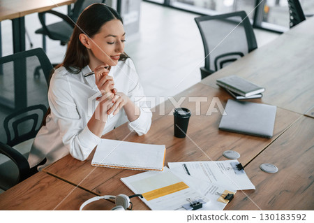Daily routine work. Businesswoman is indoors in the office Daily routine work. Businesswoman is indoors in the office 130183592