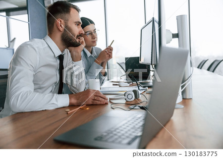 Conception of teamwork. Two employees are in the office together 130183775