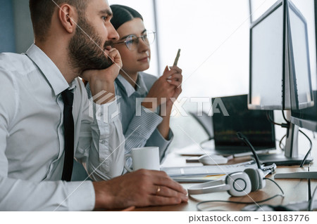 Analyzing information. Two employees are working in the office together 130183776