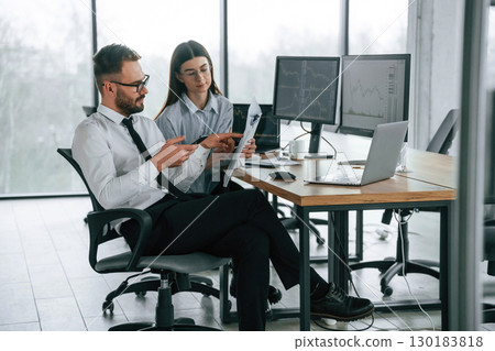 Man is using smartphone. Two employees are working in the office together Man is using smartphone. Two employees are working in the office together 130183818
