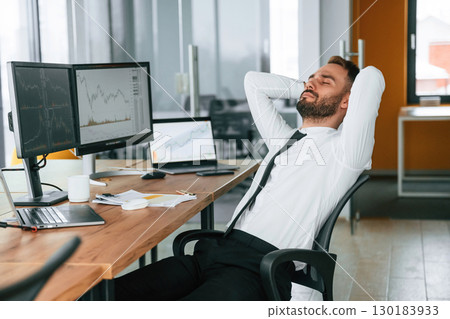 Taking a break, resting. Businessman is sitting by computer and working in the office 130183933