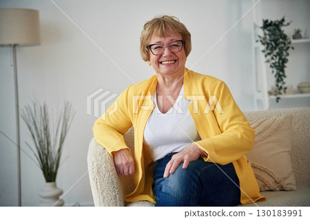 On a cozy sofa. Senior elderly woman is at home in the living room On a cozy sofa. Senior elderly woman is at home in the living room 130183991