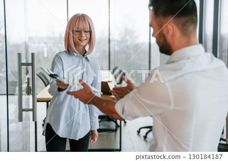 Man and woman are working in the office together Man and woman are working in the office together 130184187