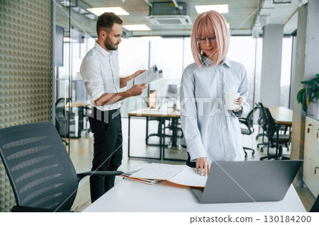 Dealing with documents. Man and woman are working in the office together Dealing with documents. Man and woman are working in the office together 130184200