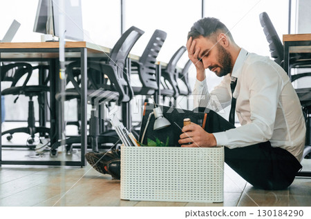Drinking alcohol. Unemployed man is with personal belongings after being fired Drinking alcohol. Unemployed man is with personal belongings after being fired 130184290