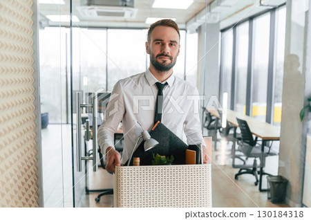 Walking forward. Unemployed man is with personal belongings after being fired 130184318