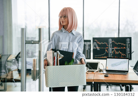 Unemployed woman with pink hair is with personal belongings after being fired 130184332