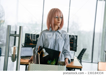 Unemployed woman with pink hair is with personal belongings after being fired 130184334