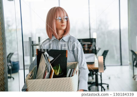 With personal belongings in the box. Unemployed woman is after being fired 130184339