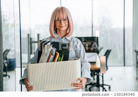 With personal belongings in the box. Unemployed woman is after being fired 130184340