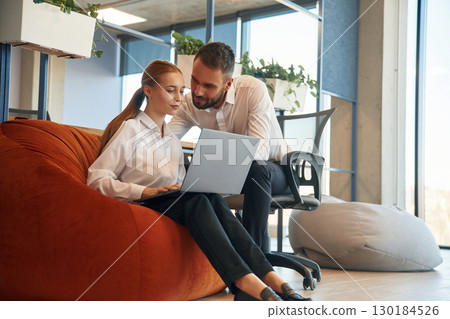 Affectionate lovely look. Man and woman employees are working in the office Affectionate lovely look. Man and woman employees are working in the office 130184526