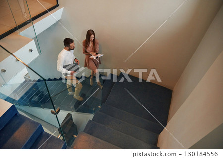 Walking on the stairs. Man and woman are on the way to work to office 130184556
