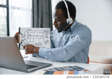Showing plan, online meeting. Businessman is working in the office by laptop Showing plan, online meeting. Businessman is working in the office by laptop 130184778