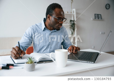 Doing some paperwork. Businessman is in the office by laptop 130184793