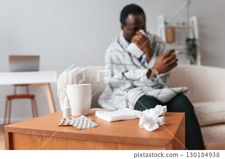 Looking at thermometer. Sick black man is at home 130184938