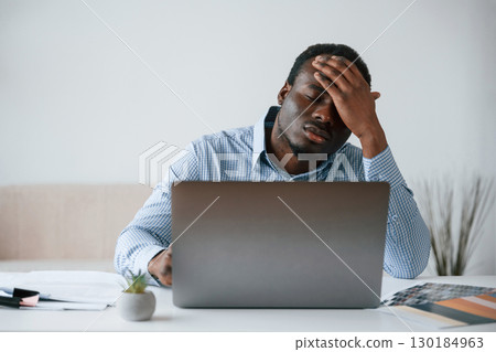 Feeling bad, stressful. Businessman is working in the office by laptop Feeling bad, stressful. Businessman is working in the office by laptop 130184963
