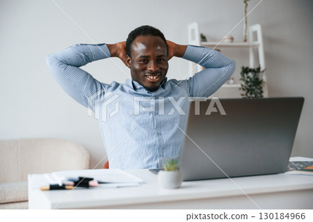 Front view. Businessman is working in the office by laptop Front view. Businessman is working in the office by laptop 130184966