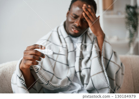 Horrible headache. Sick black man is at home 130184979