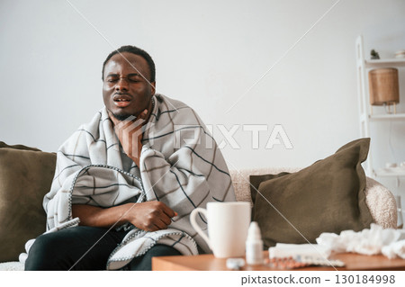 Pain in the throat. Sick black man is at home Pain in the throat. Sick black man is at home 130184998