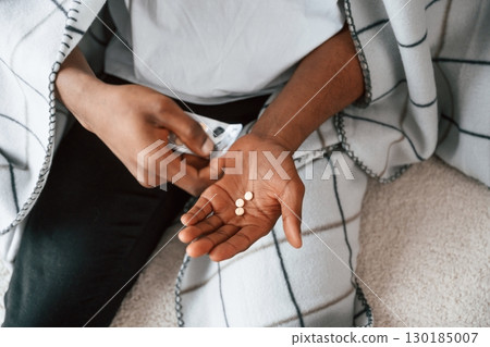 Taking the pills. Sick black man is at home 130185007
