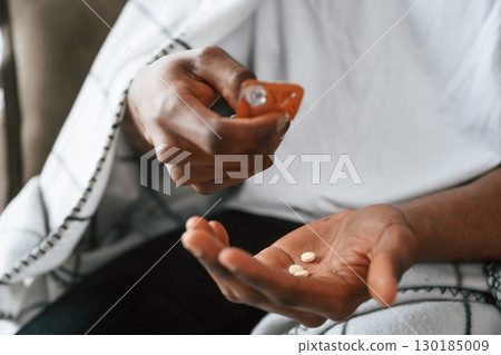 Taking the pills. Sick black man is at home Taking the pills. Sick black man is at home 130185009