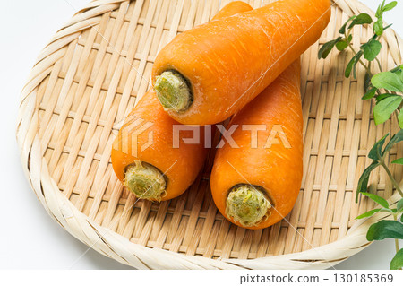 Fresh carrots arranged in a colander 130185369
