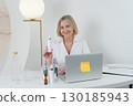 A Professional Woman Surrounded by Skincare Products Inside a Contemporary Modern Workspace 130185943