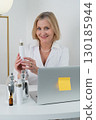 A Professional Woman Surrounded by Skincare Products Inside a Contemporary Modern Workspace 130185944